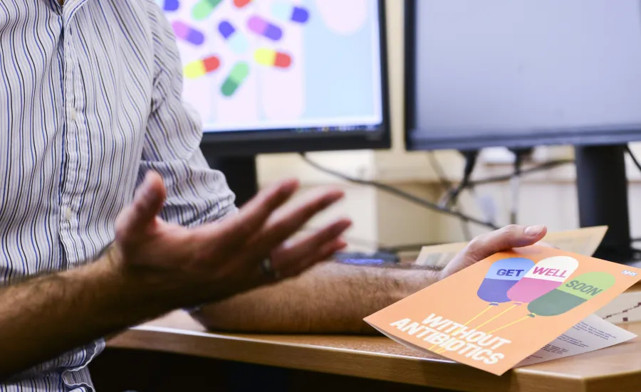 A hand holding a get well without antibiotics card